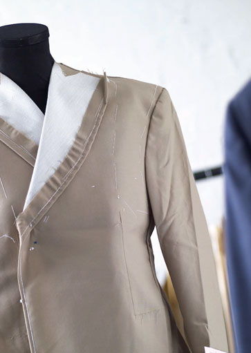 A half-made jacket pinned on a tailor's form